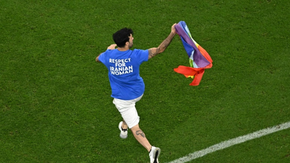 Un hombre con una bandera arco&iacute;ris entra en la cancha del Portugal-Uruguay